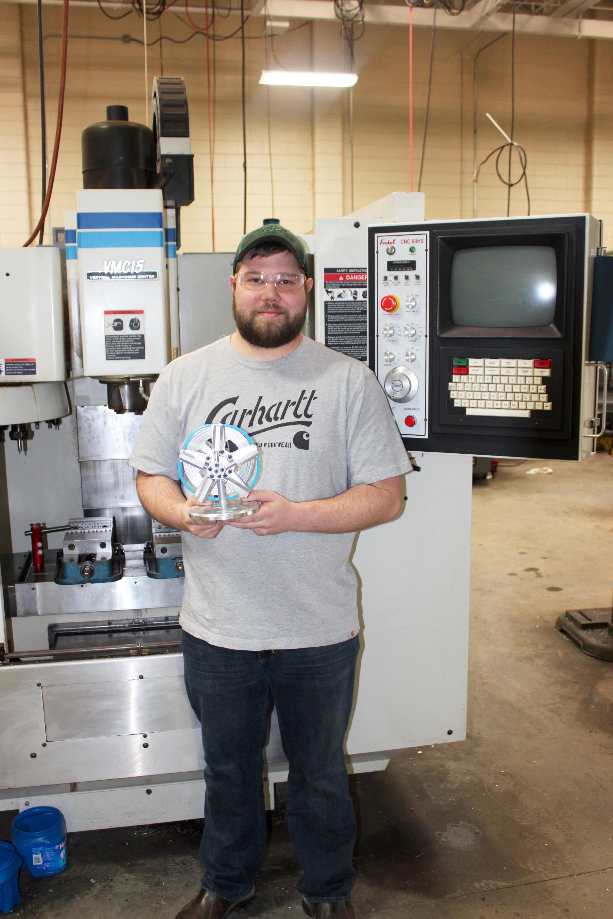 Student holding machining project