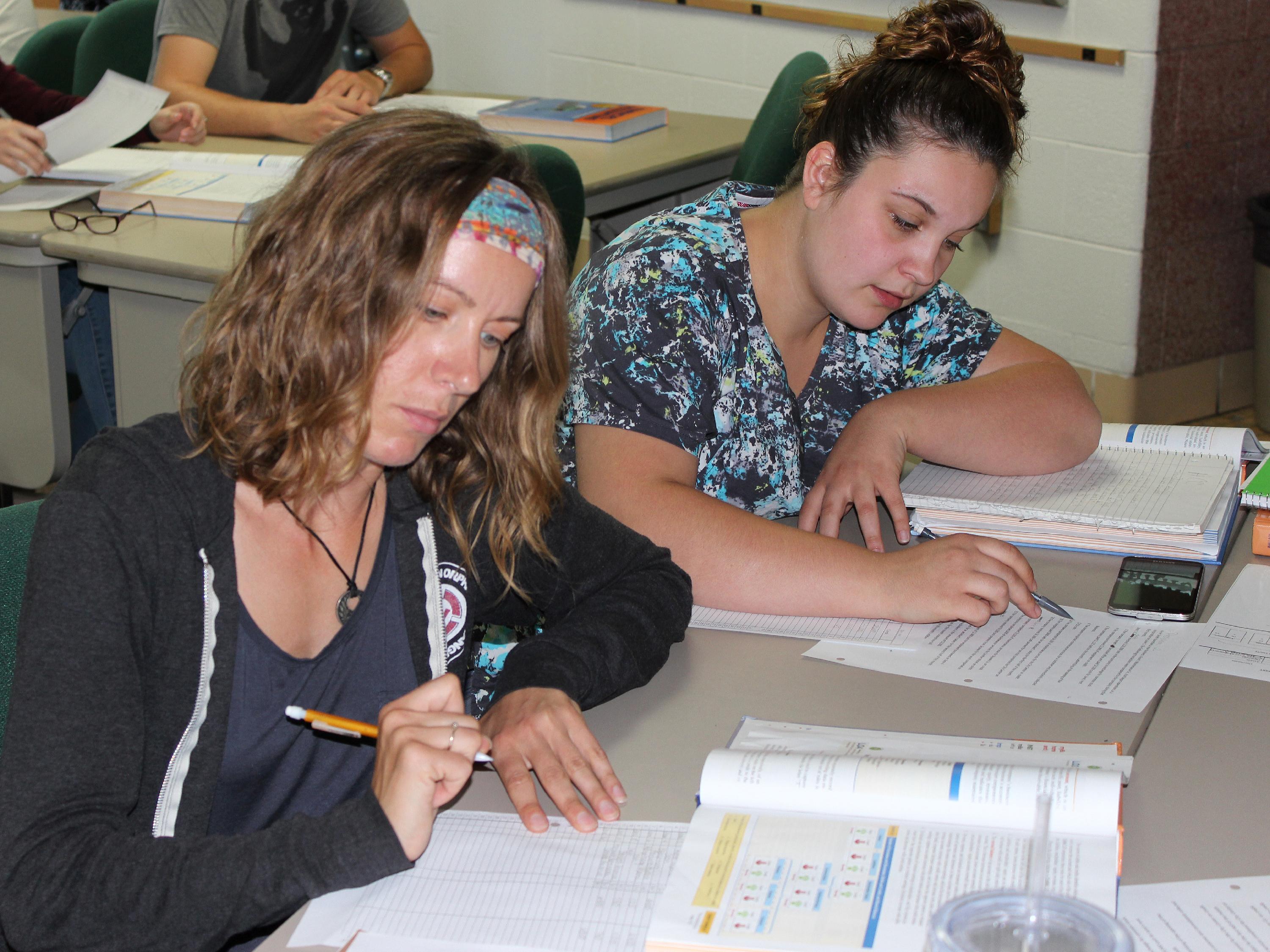 Two female students working on accounting homework