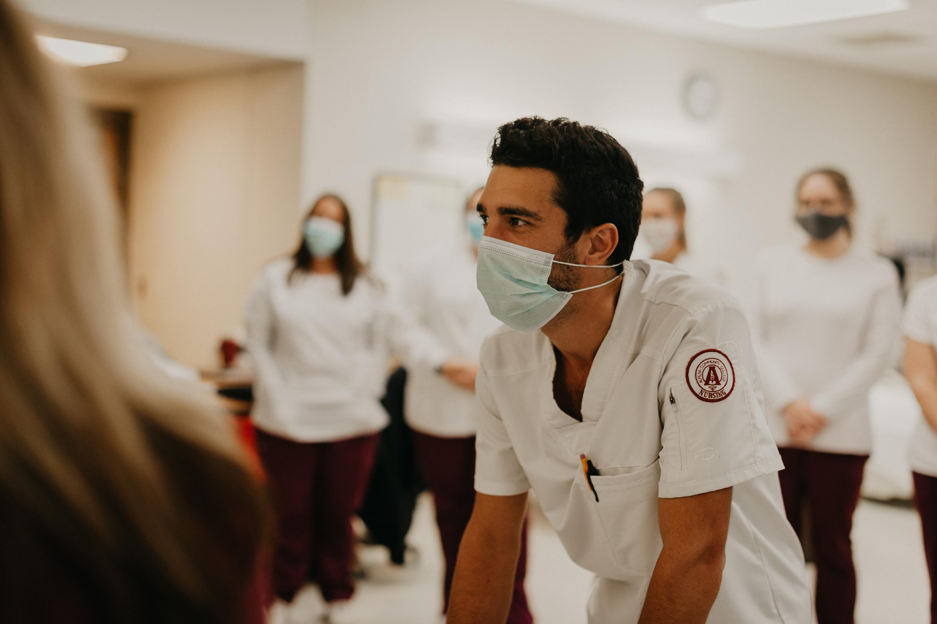 Nursing student crouching in front of a group of fellow students