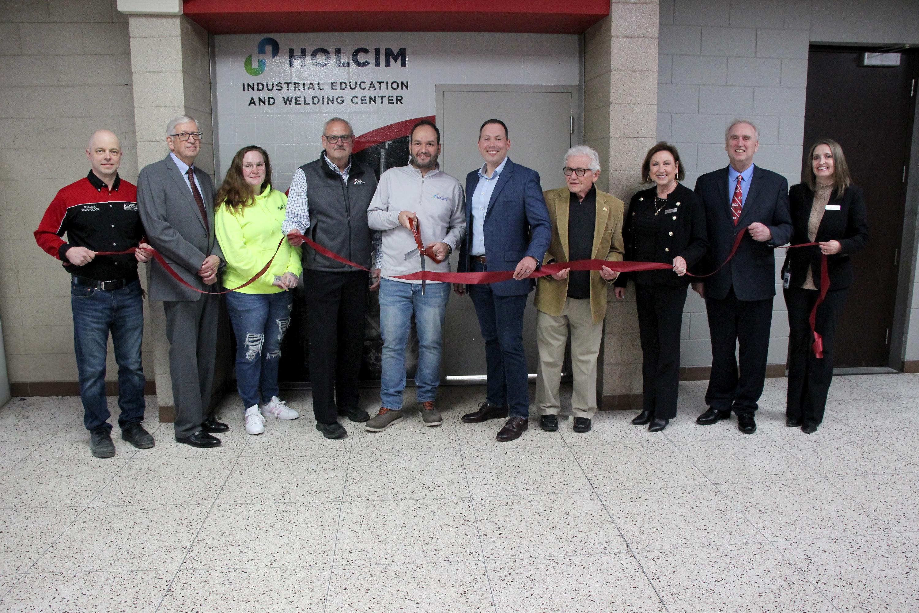 A group of people cut the ribbon at the updated welding lab