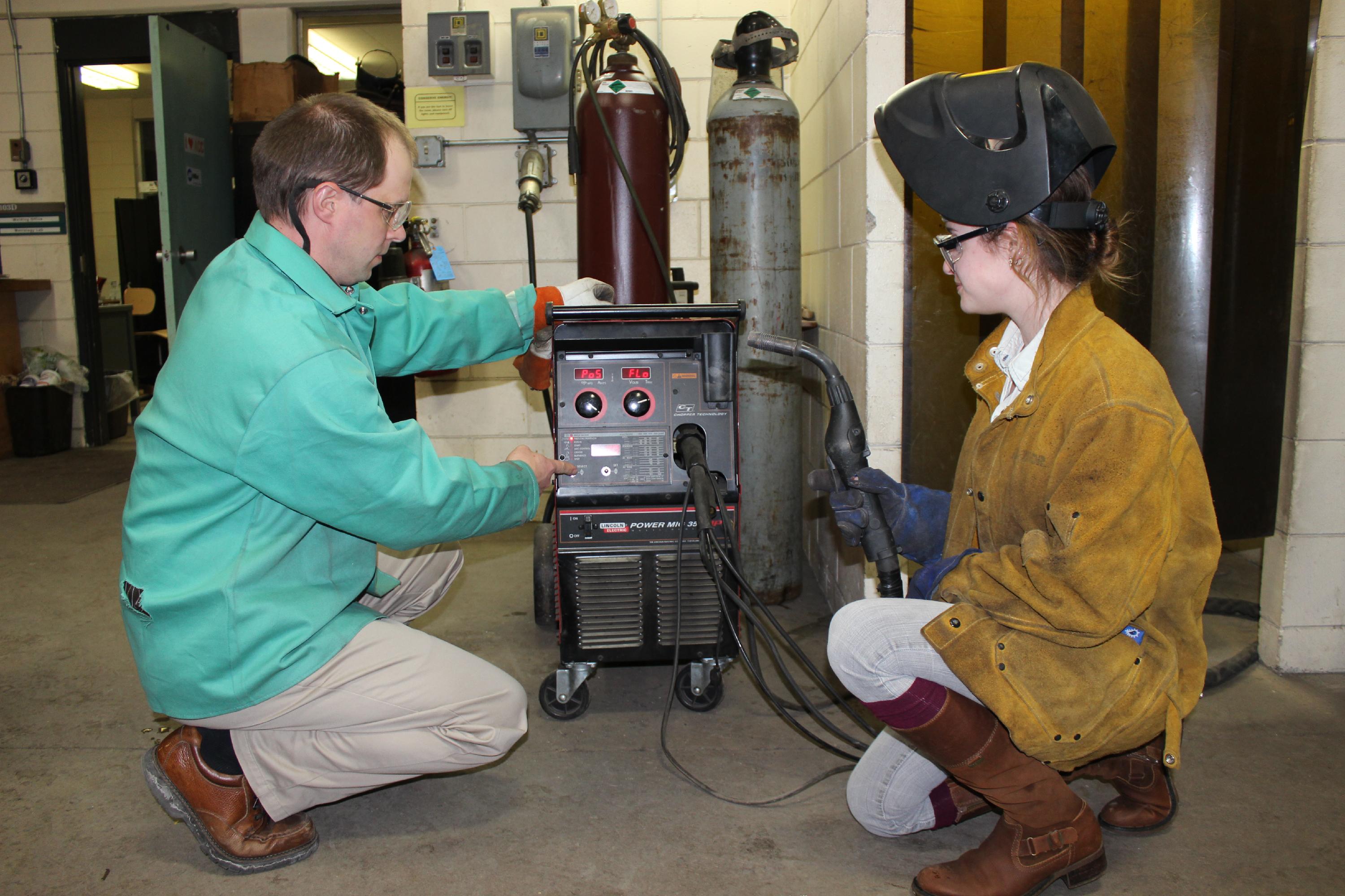 Instructor and student working with welding equipment