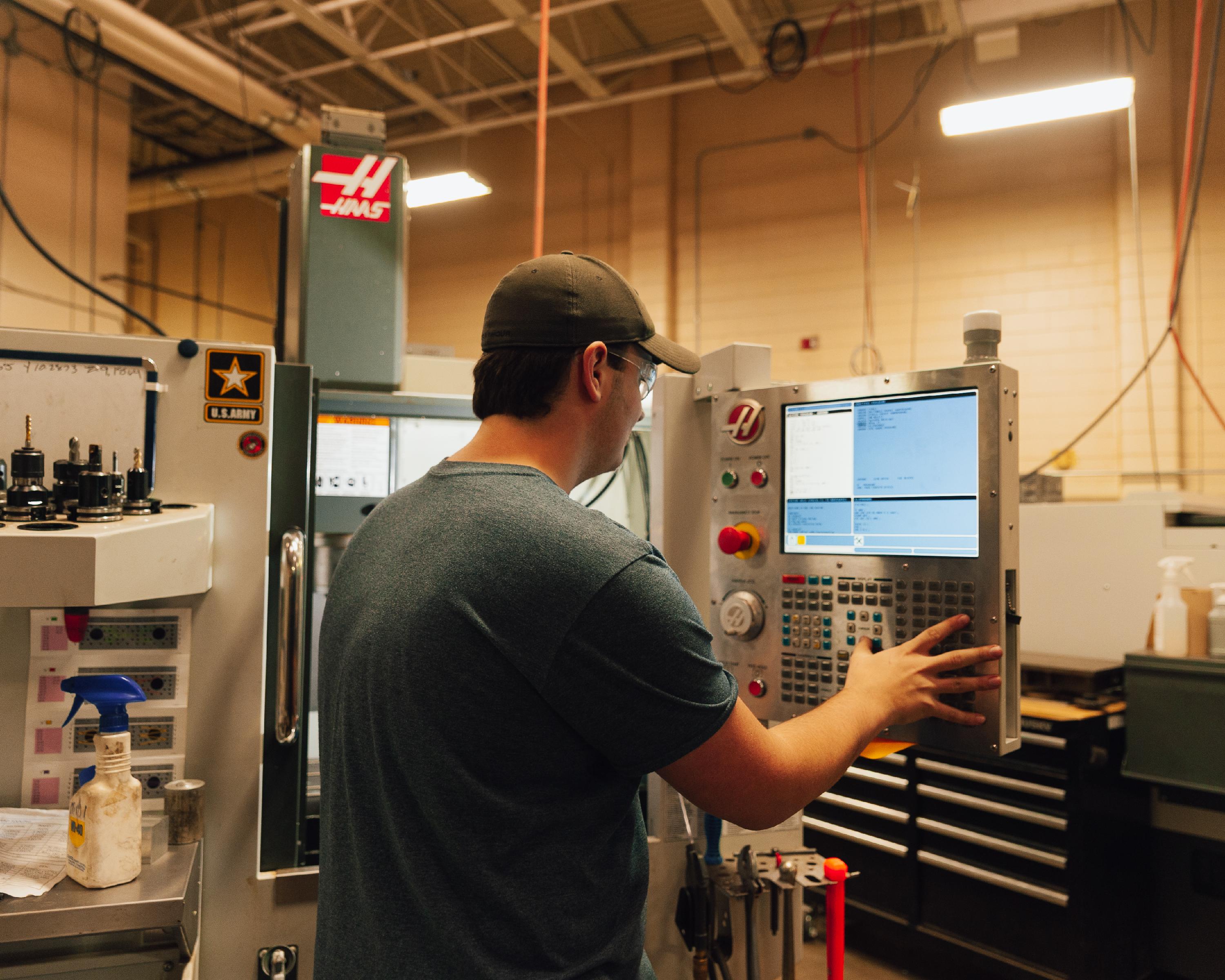 Student working in front of computer screen in machine tool lab