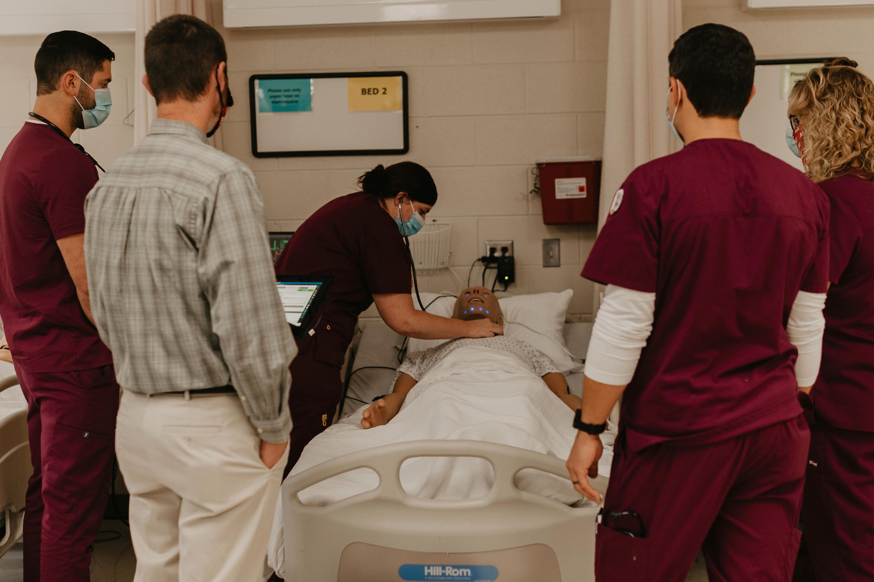 A group of students work on a manikin in the lab