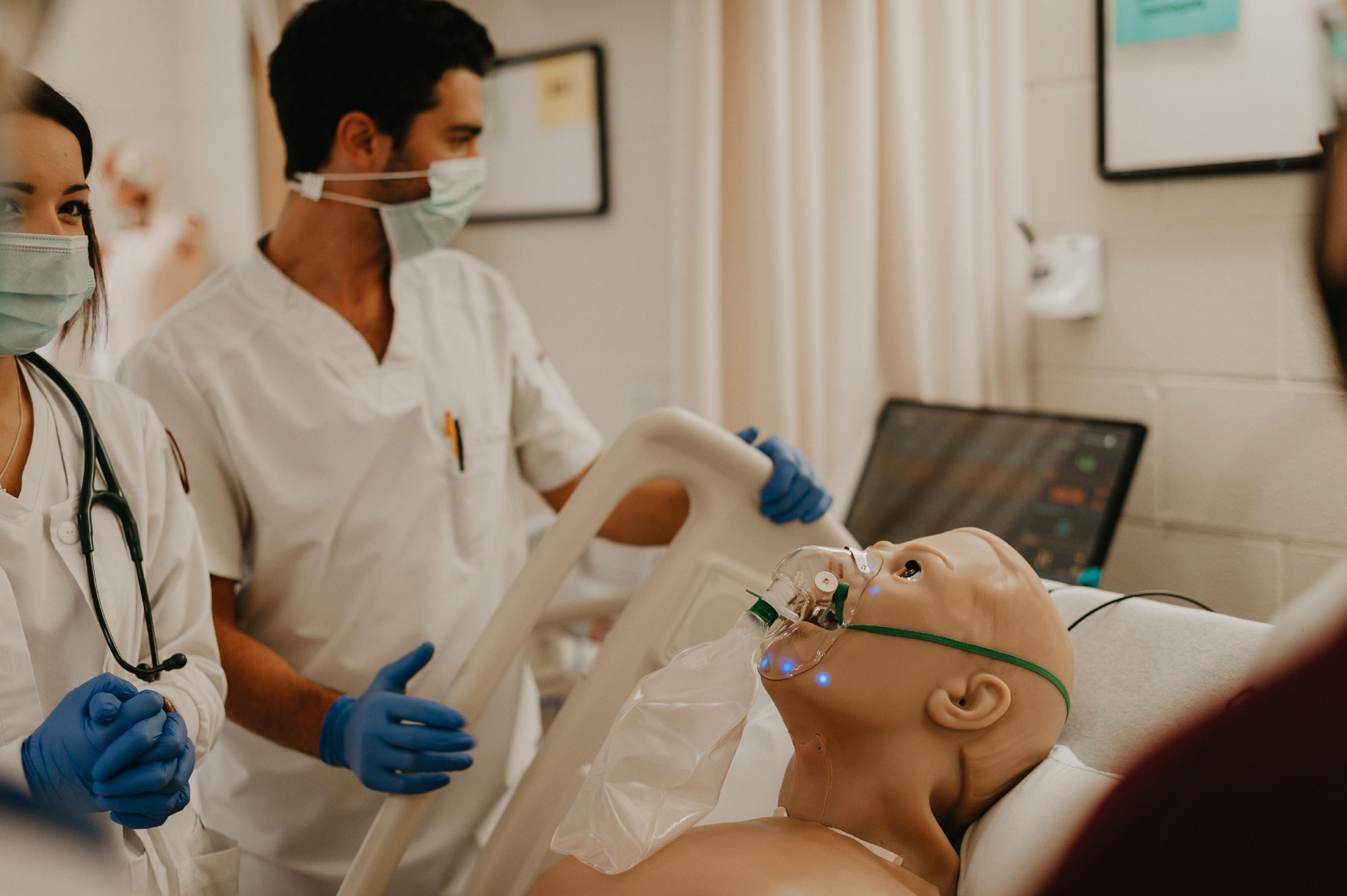 Nursing students work with a respirator on a manikin